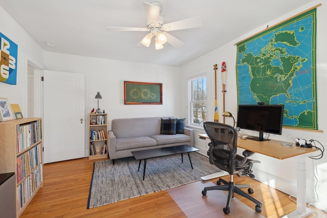 office area with light wood finished floors and ceiling fan