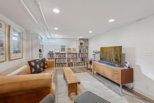 living room featuring light wood finished floors, baseboards, and recessed lighting