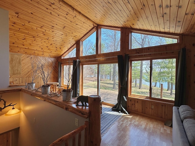 14788 Coyote Dr, Park Rapids, MN 56470 - living room with wooden walls, healthy amount of natural light, wooden ceiling, light wood-style floors, and a water view