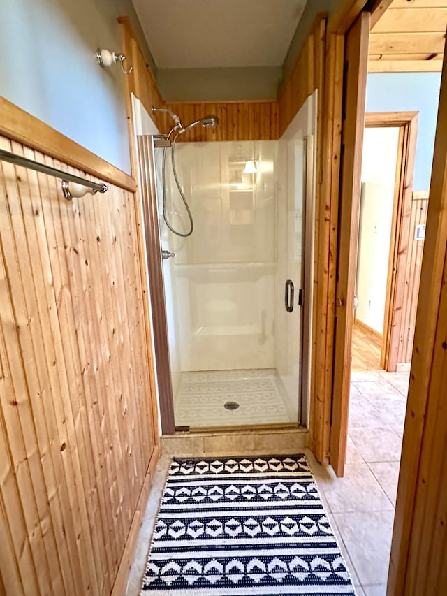 14788 Coyote Dr, Park Rapids, MN 56470 - bathroom with a shower stall, tile patterned floors, and wood walls