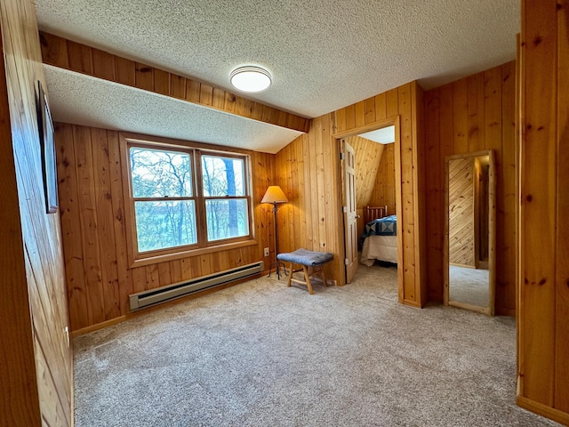 14788 Coyote Dr, Park Rapids, MN 56470 - bedroom featuring a baseboard heating unit, carpet flooring, a textured ceiling, and wood walls