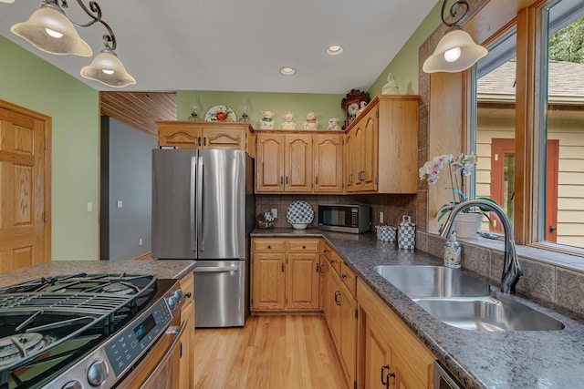 kitchen featuring a sink, hanging light fixtures, light wood-style floors, appliances with stainless steel finishes, and recessed lighting