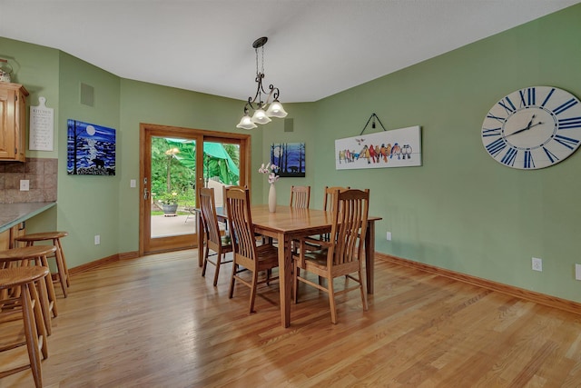 dining area with light wood-type flooring, baseboards, and visible vents