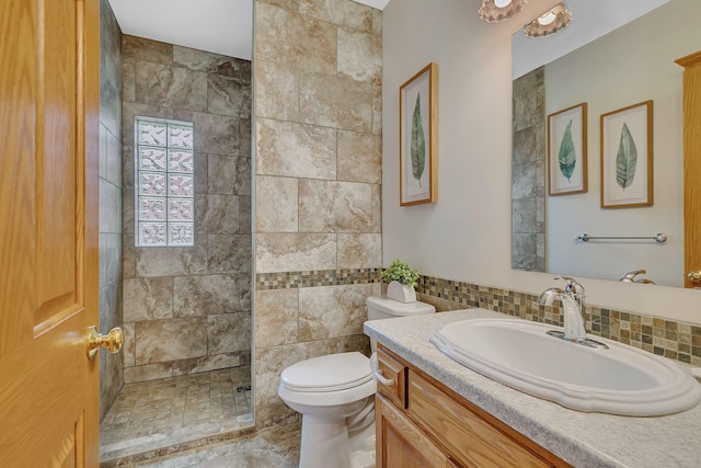 bathroom with tasteful backsplash, vanity, tile walls, walk in shower, and toilet