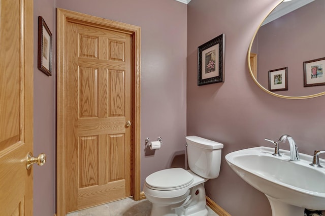bathroom featuring toilet, tile patterned flooring, a sink, and baseboards