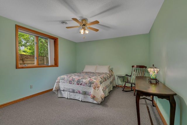 carpeted bedroom featuring visible vents, baseboards, a textured ceiling, and ceiling fan