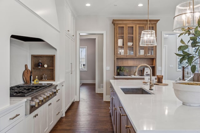 kitchen with sink, white cabinetry, backsplash, hanging light fixtures, and stainless steel gas stovetop