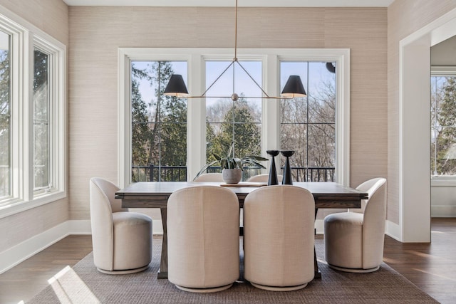dining area featuring dark wood-type flooring and a notable chandelier