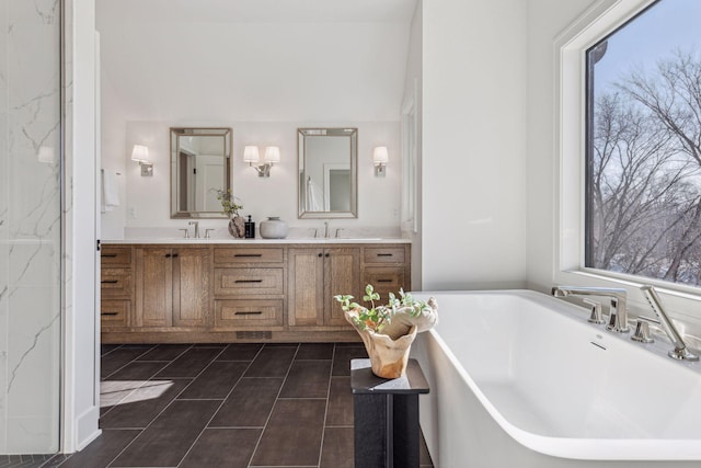 bathroom featuring a tub to relax in, tile patterned floors, and vanity