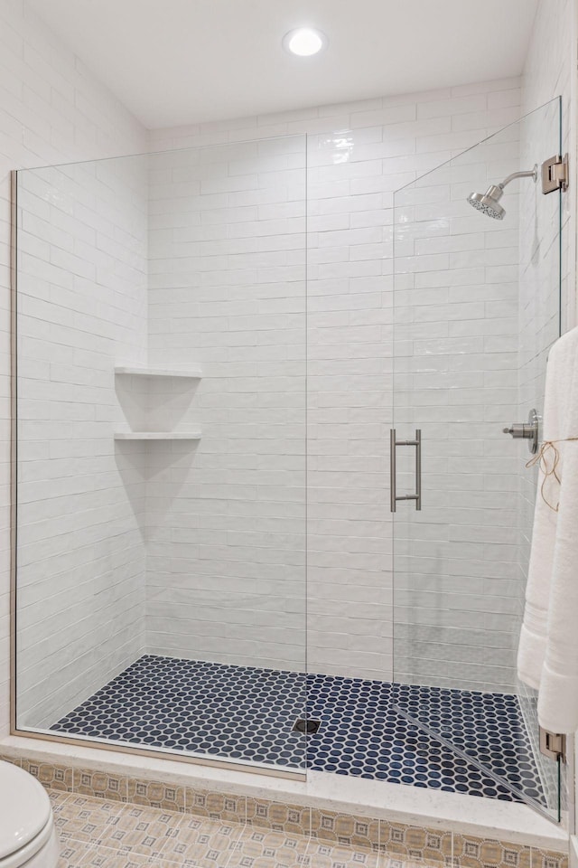 bathroom with toilet and an enclosed shower