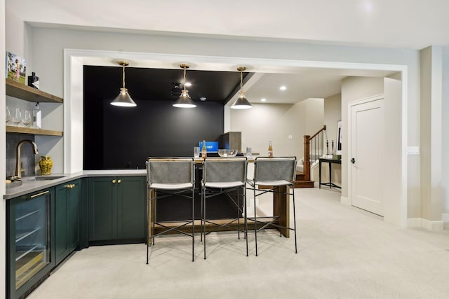 bar featuring decorative light fixtures, sink, beverage cooler, green cabinetry, and light carpet