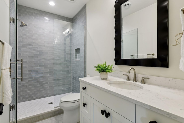 bathroom with vanity, an enclosed shower, and toilet