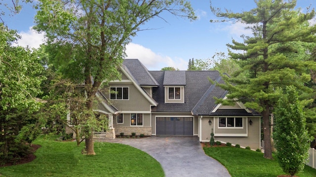 craftsman inspired home with a garage and a front yard