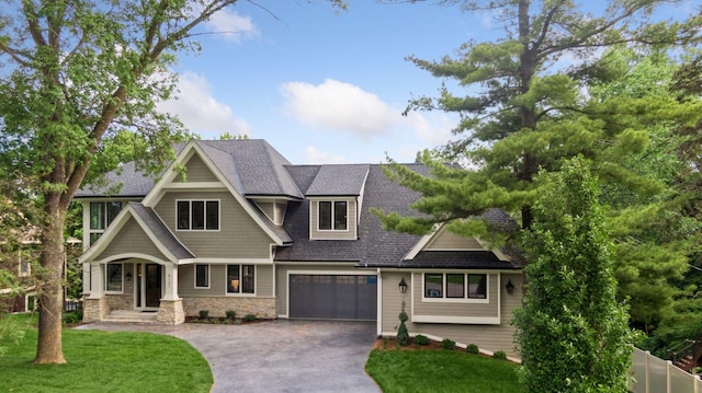 craftsman house with a garage and a front lawn