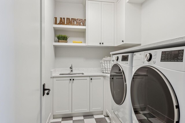 laundry room featuring sink, washer and clothes dryer, and cabinets