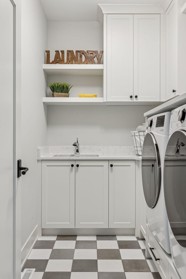 laundry room with cabinets, sink, and washing machine and clothes dryer