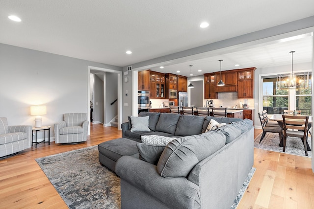 living room with a chandelier and light hardwood / wood-style flooring