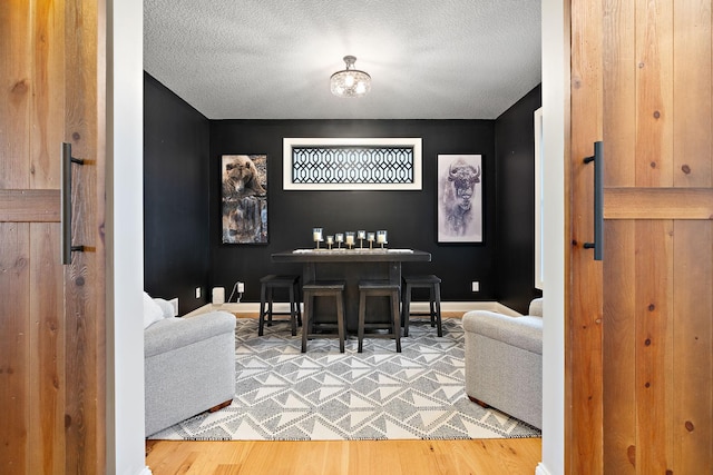 dining room with hardwood / wood-style flooring and a textured ceiling