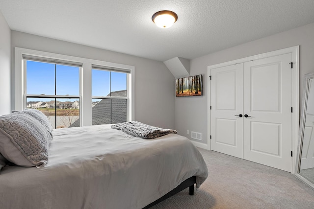 bedroom featuring a closet, a textured ceiling, and carpet flooring