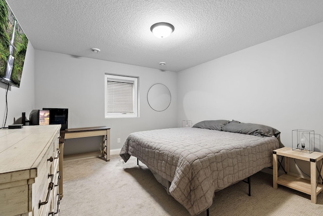 bedroom featuring light colored carpet and a textured ceiling