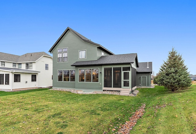 rear view of house featuring a sunroom and a yard