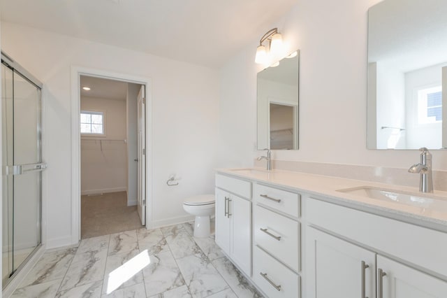 full bath featuring a spacious closet, a shower stall, marble finish floor, and a sink