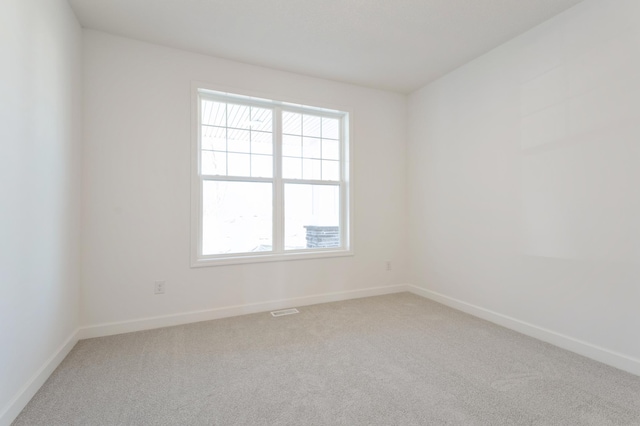 spare room with visible vents, baseboards, and carpet floors