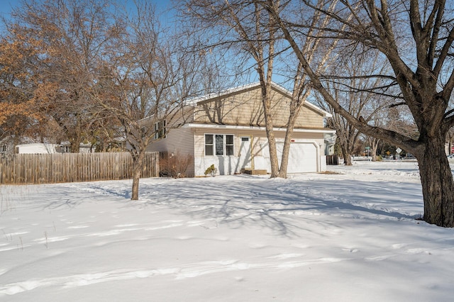 exterior space with brick siding, an attached garage, and fence