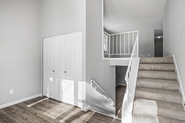 stairs featuring wood finished floors and baseboards