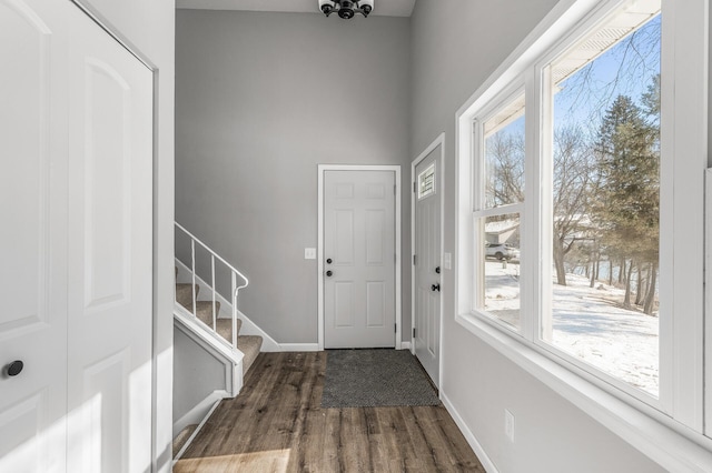 doorway to outside with stairway, baseboards, and wood finished floors