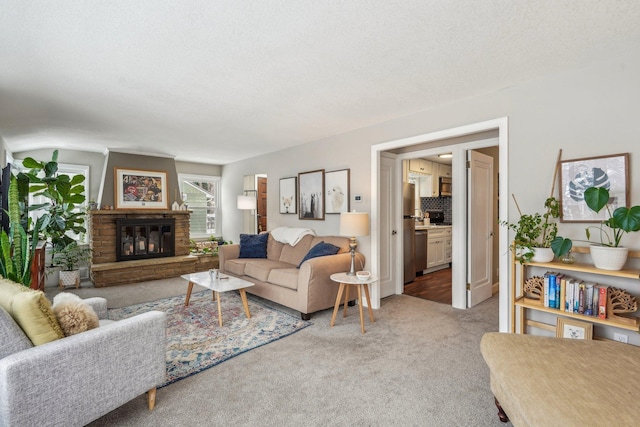 living area featuring a glass covered fireplace and carpet flooring