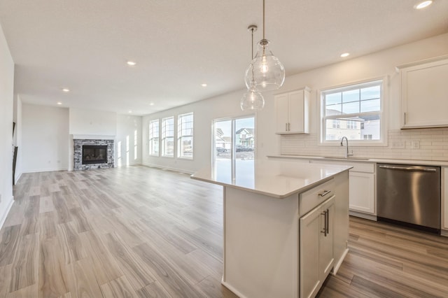 kitchen featuring a center island, sink, stainless steel dishwasher, and white cabinets