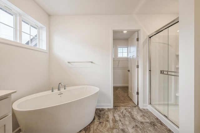 bathroom featuring vanity and independent shower and bath