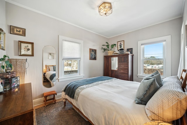 bedroom featuring crown molding, baseboards, and wood finished floors