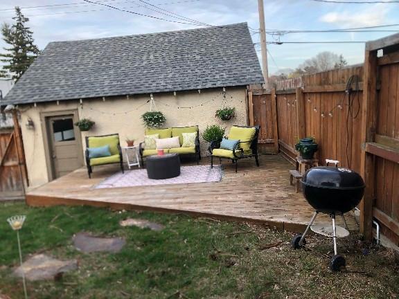 deck with a grill, outdoor lounge area, and fence