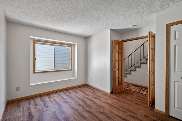 spare room featuring hardwood / wood-style flooring and a textured ceiling