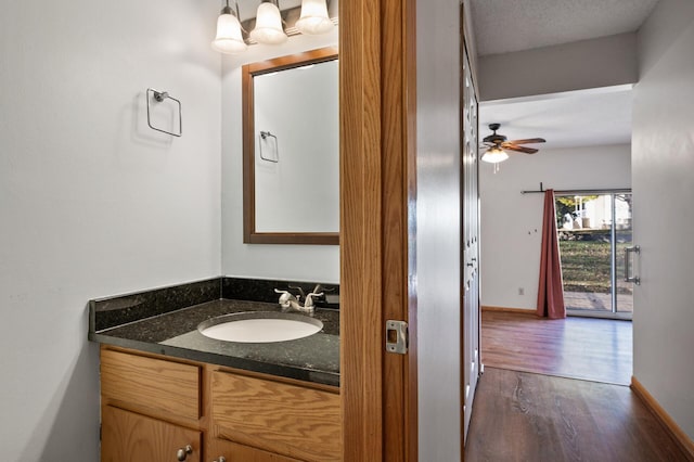 bathroom featuring ceiling fan, wood-type flooring, and vanity