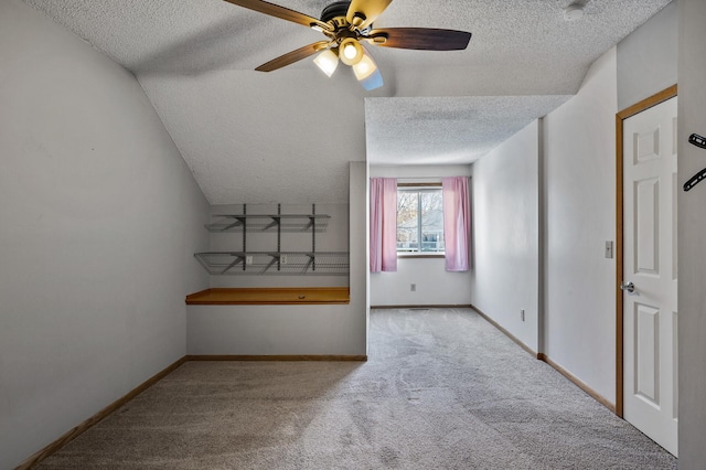 additional living space featuring ceiling fan, light colored carpet, and a textured ceiling