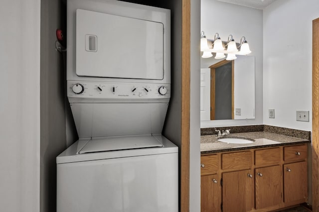 laundry area featuring stacked washer / dryer and sink