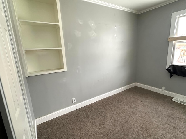 carpeted spare room featuring crown molding