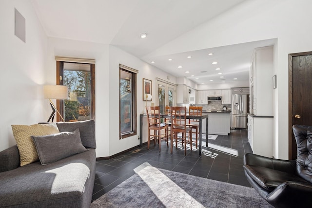 living room with recessed lighting, baseboards, lofted ceiling, and dark tile patterned flooring