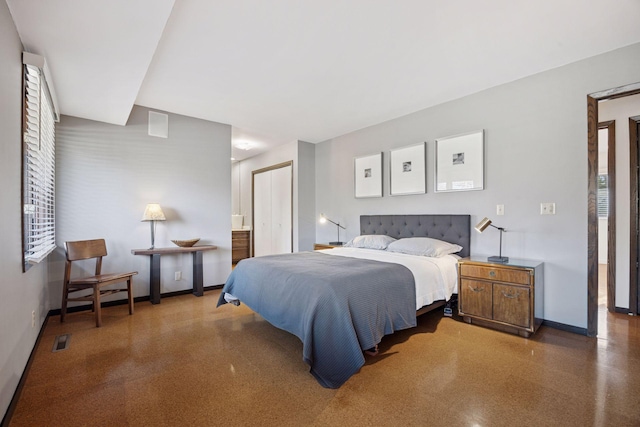 bedroom with visible vents, baseboards, speckled floor, and ensuite bathroom