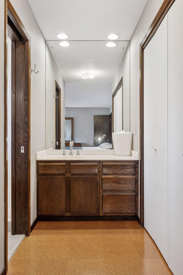 bathroom with vanity, recessed lighting, and carpet