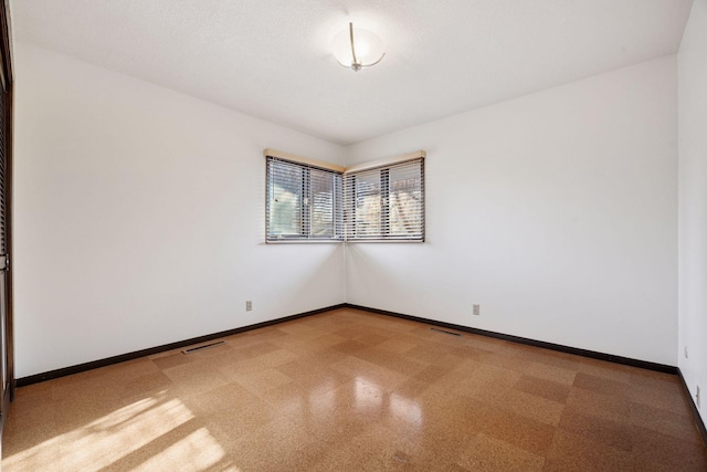 spare room with visible vents and baseboards