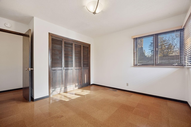 unfurnished bedroom featuring a closet, baseboards, and visible vents