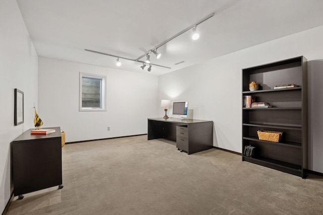 office featuring track lighting, light colored carpet, and baseboards