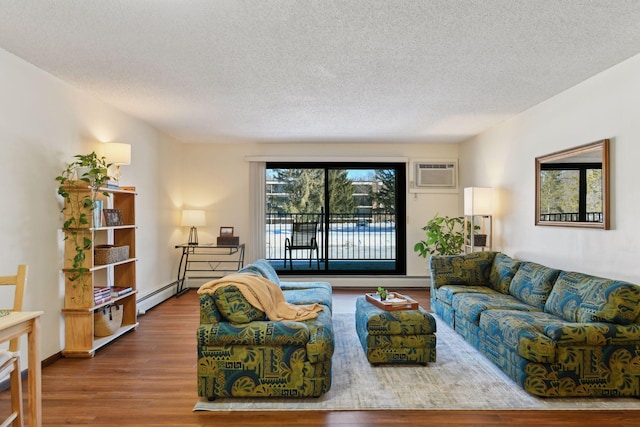 living room with a baseboard heating unit, a textured ceiling, a wall mounted air conditioner, and wood finished floors