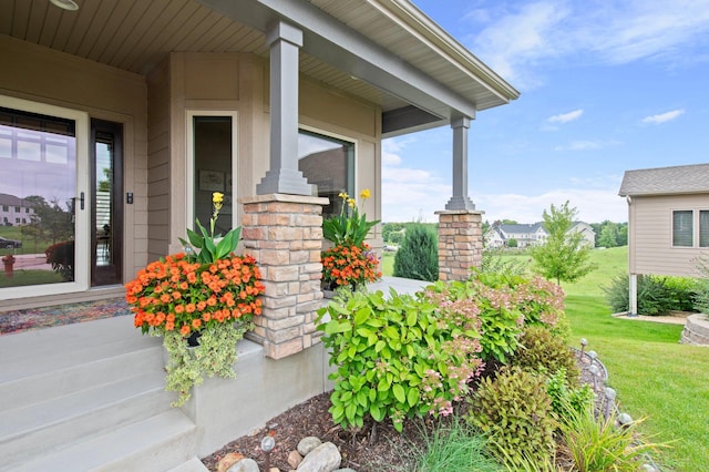 view of exterior entry with a yard