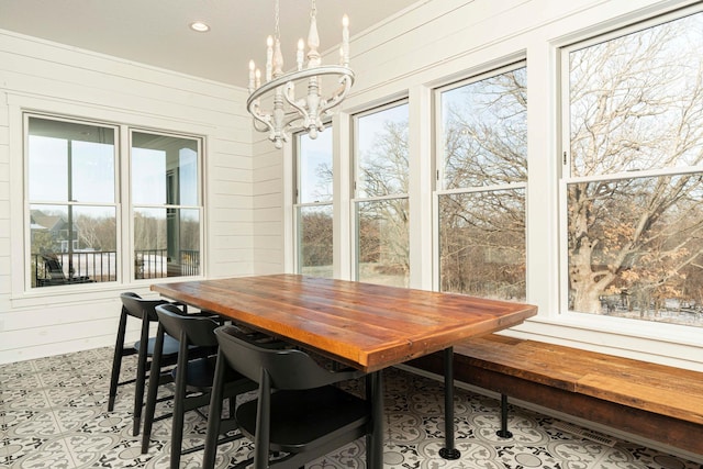 771 Zumbro Oaks Ln NW, Oronoco, MN 55960 - dining room featuring a chandelier, wooden walls, and plenty of natural light