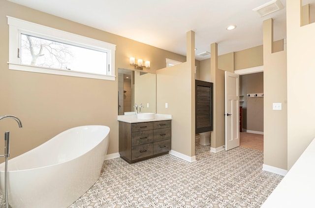 771 Zumbro Oaks Ln NW, Oronoco, MN 55960 - bathroom with a freestanding bath, vanity, visible vents, and recessed lighting